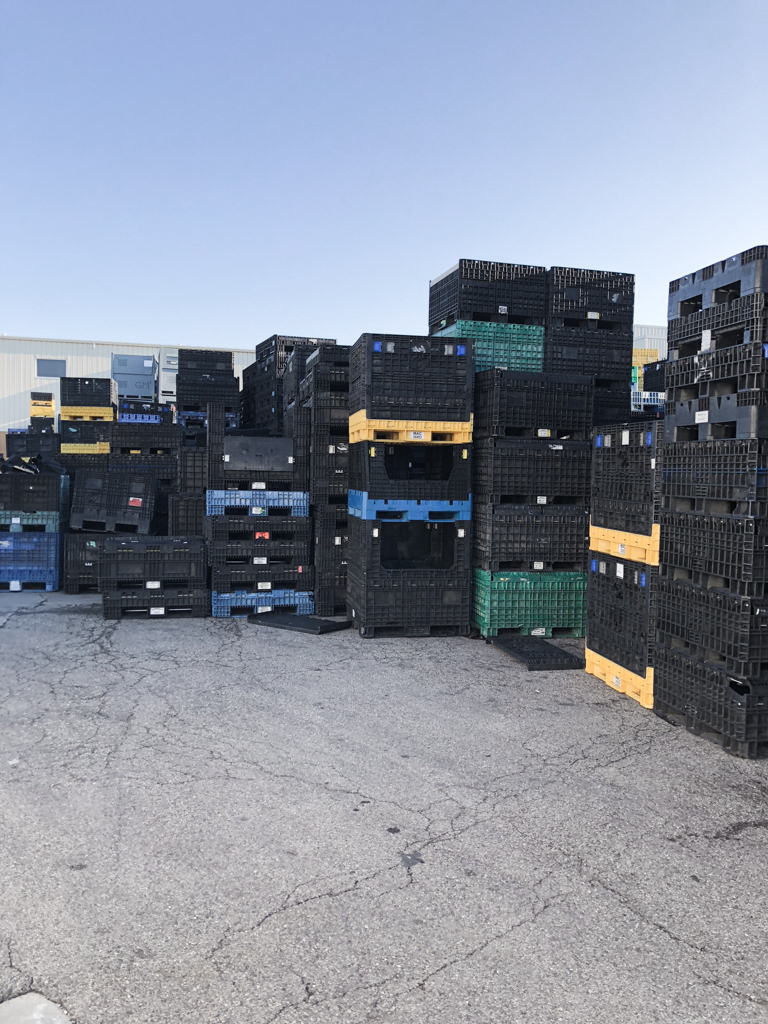 Stacked bulk plastic containers after repairs have been performed.