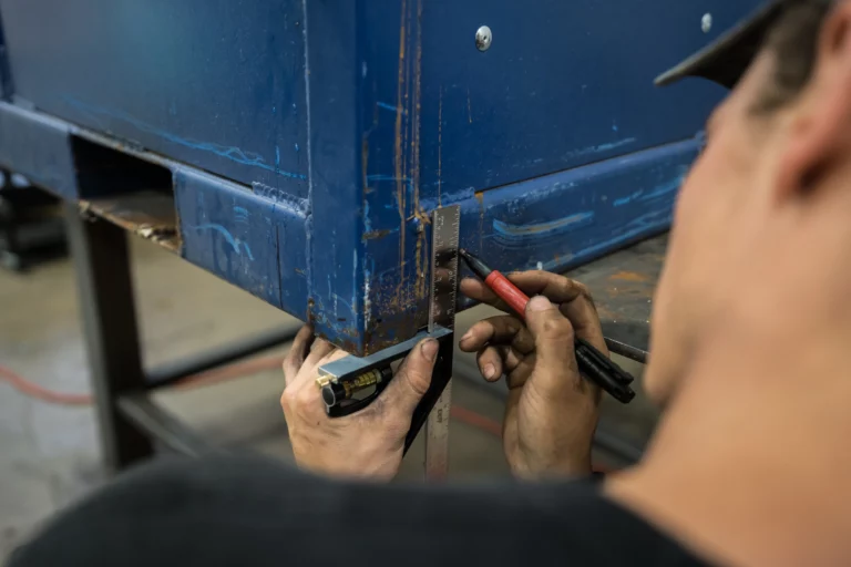 Michigan Industrial Container employee modifies a blue steel automotive rack.